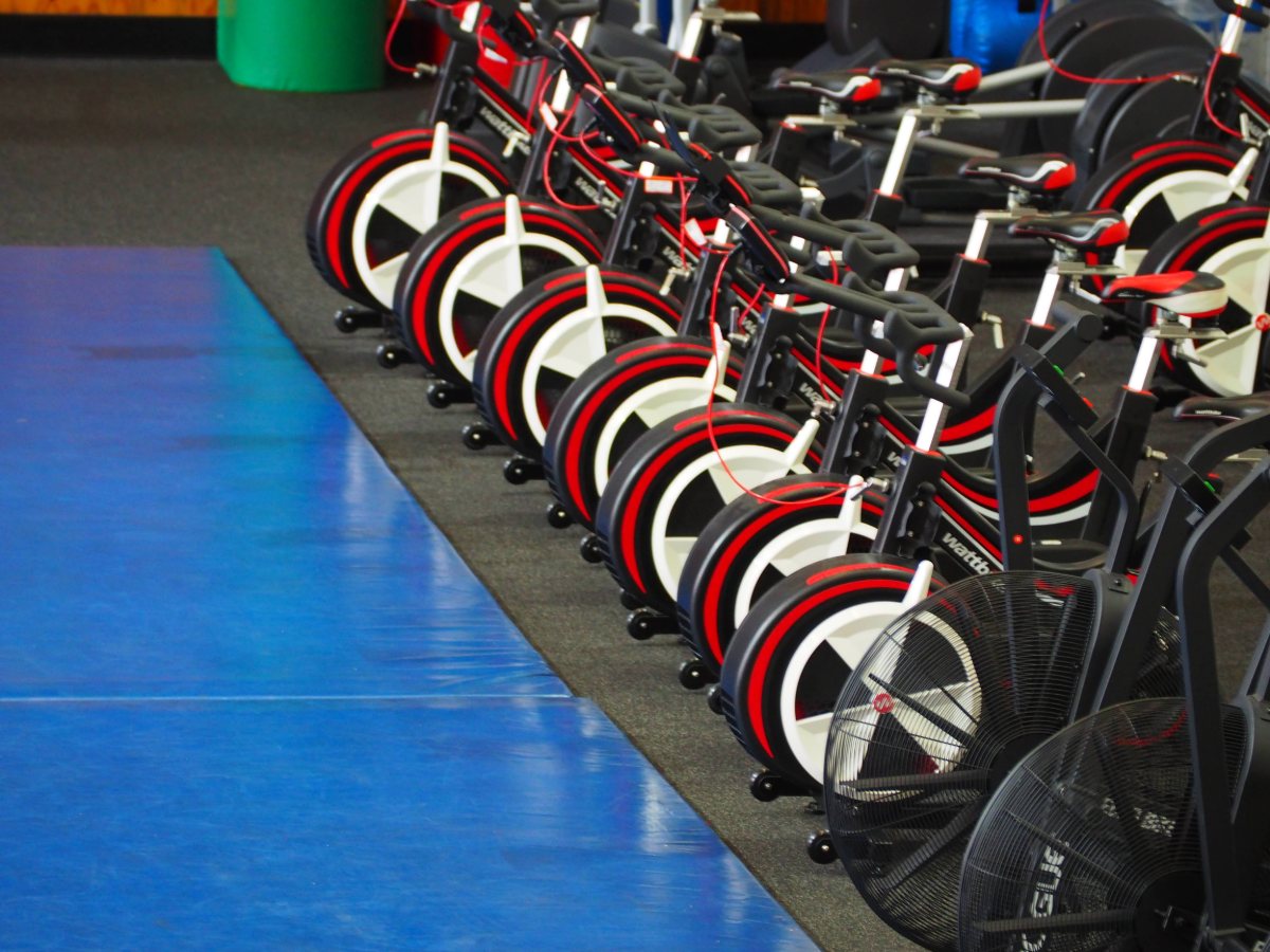 Fila de bicicletas estáticas en un gimnasio.