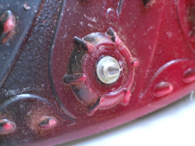 Primer plano de un clavo de atletismo enroscado en la suela de una zapatilla.