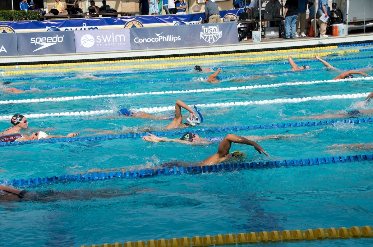 Nadadores calentando en una piscina antes de una competición.