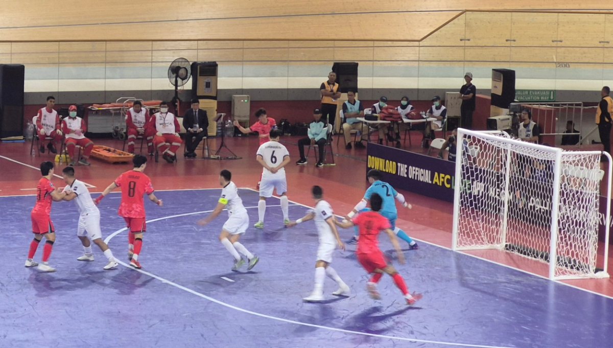 Jugadores disputando un partido de fútbol sala junto a la portería.